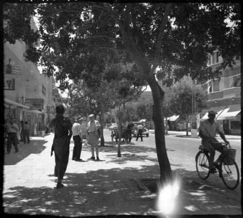 Stereos, Tel Aviv, taken 6th Aug 41 [6 August 1941, street scene of shopfronts and  men in conversation, 1] [picture] / [Frank Hurley]