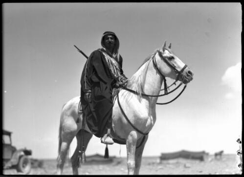 [Arab horseman mounted on horse, with a car in the background] [picture] / [Frank Hurley]