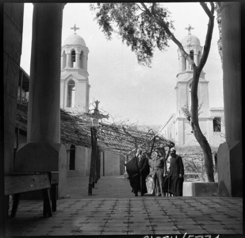 Wady Latron [three men in the courtyard of the unidentified church] [picture] / [Frank Hurley]