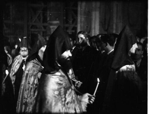 The Armenian Service, Church of the Holy Sepulchre [hooded priests with candles] [picture] / [Frank Hurley]