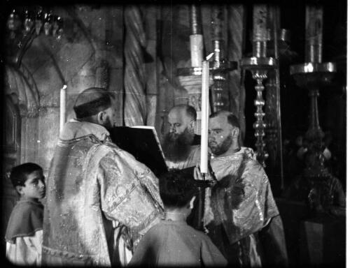 The Armenian Service, Church of the Holy Sepulchre [priests at the altar, reading from the scriptures] [picture] / [Frank Hurley]