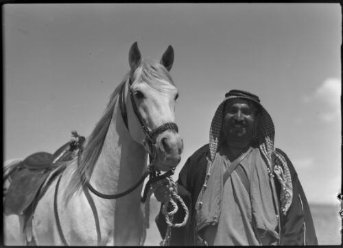 [Man in Arab headdress posing with horse] [picture] : [Jordan] / [Frank Hurley]