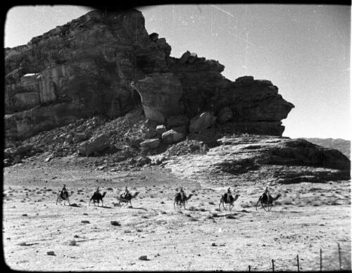 Camels, camel detachment [mounted troops in single file, in profile, long shot, 2] [picture] : [Jordan] / [Frank Hurley]