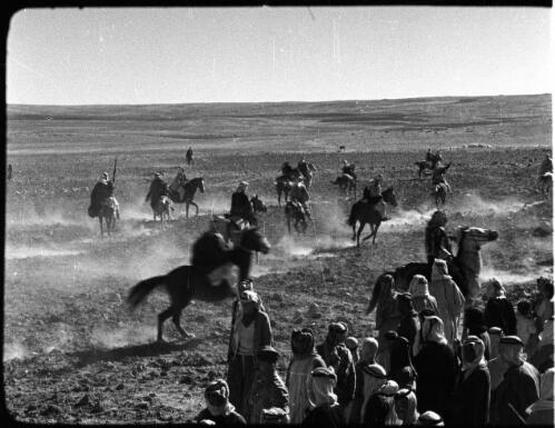 Kerak [Bedouin group watching other Bedouins on horseback, 2] [picture] : [Jordan] / [Frank Hurley]