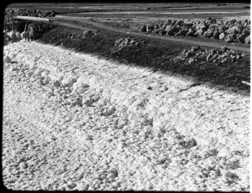 Dead Sea [rocky foreground, raised dirt road on an embankment middleground] [picture] : [Jordan] / [Frank Hurley]