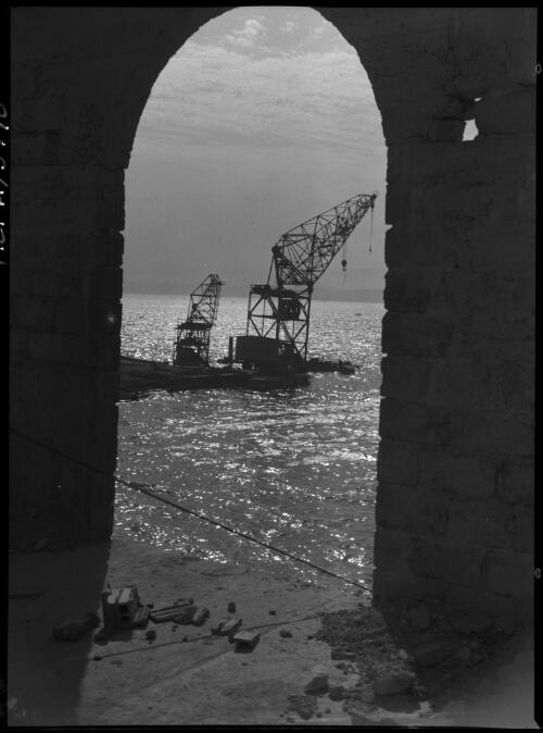 Scenes taken in the vicinity of Tobruch [Tobruk] during the 1st battle in which the 6th Div were engaged [harbour scene with cranes] [picture] : [Barqah, Libya] / [Frank Hurley]