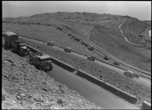 [Convoy of Allied military vehicles on a winding road, coast below, ca. 1940-1946] [picture] : [Barqah, Libya] / [Frank Hurley]