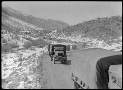 Indian troops leaving trucks at rest camp Karind Persia  [a convoy of trucks on the road] [picture] : [Iran, World War II] / [Frank Hurley]