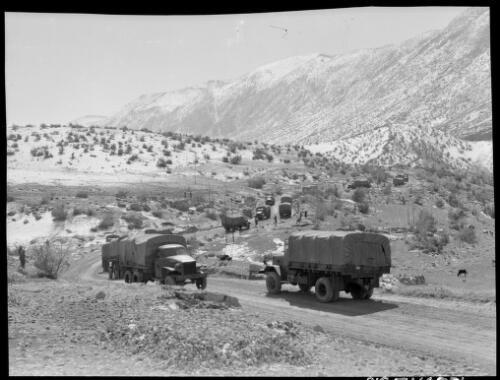 Indian troops leaving trucks at rest camp Karind Persia  [trucks on the road] [picture] : [Iran, World War II] / [Frank Hurley]