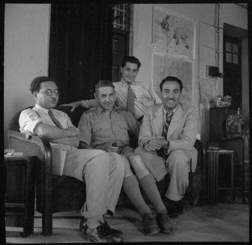 [Four men seated in front of maps including one headed Philips' War Map of Europe, World War II] [picture] : [Iran] / [Frank Hurley]