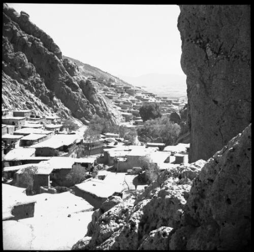 [Panorama of a town of old flat roofed buildings nestled in the side of a rocky and barren mountain, World War II] [picture] : [Iran] / [Frank Hurley]