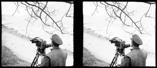 [Camera and cameraman in foreground, convoy of trucks descending in the valley in the background, World War II] [picture] : [Iran] / [Frank Hurley]