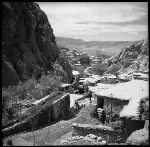 Sunday shots, Iran [flat roofed dwellings huddled amongst a steep rocky landscape, a town of flat-roofed buildings can be seen in the middle distance, World War II] [picture] : [Iran] / [Frank Hurley]