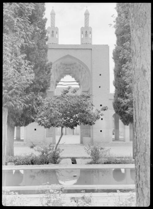 The Shrine of Mahun in the village of same name about 25 miles east of Kerman, Persia [entrance with pond in foreground] [picture] : [Iran, World War II] / [Frank Hurley]