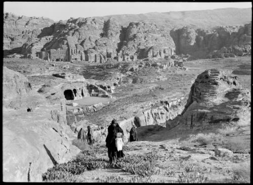 [Open expanse with Bedouins in foreground and Petra tombs in distance ca. 1940-1946] [picture] : [Petra Valley, Jordan] / [Frank Hurley]