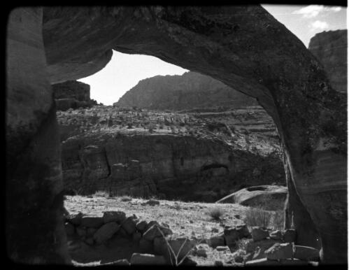 Petra [shot through a stone arch to a cliff face and distant hills ca. 1940-1946] [picture] : [Petra Valley, Jordan] / [Frank Hurley]