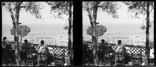 [Two Allied soldiers sit at a terrace overlooking a coastal town ca. 1940-1946] [picture] : [Petra Valley, Jordan] / [Frank Hurley]
