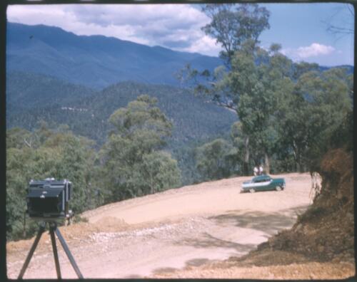 [Mountain scene with car on dirt road] [transparency] / [Frank Hurley]