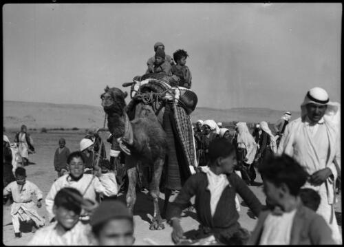 Near Esdud [two children and a man riding a camel] [picture] / [Frank Hurley]