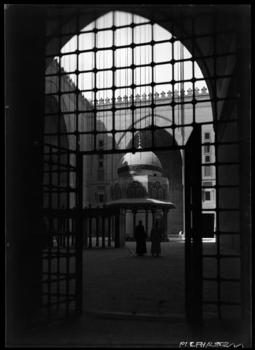 The scenes through the grille show the courtyard of Sultan Hassan Mosque & the birds eye view looks over old Cairo from the Minaret of Sultan Hassan Mosque [picture] : [Cairo, Egypt, World War II] / [Frank Hurley]
