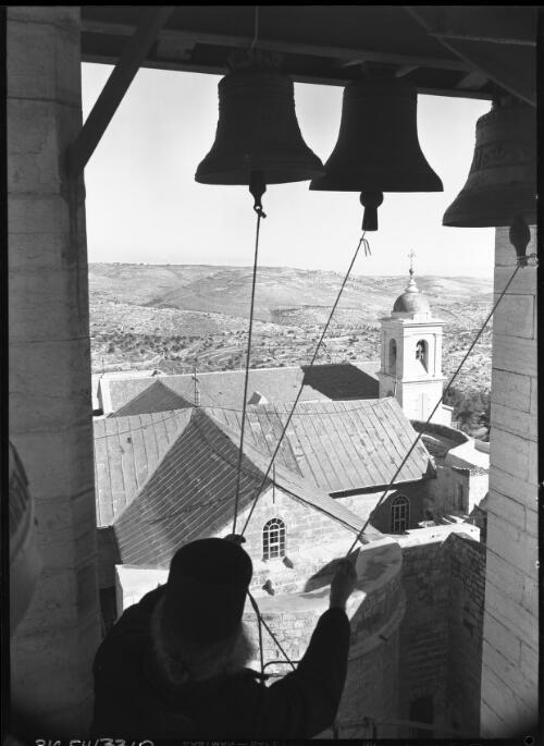 Belfrey of the Greek Basilica Bethlehem [with a figure ringing the bells, ca. 1942] [picture] / [Frank Hurley]