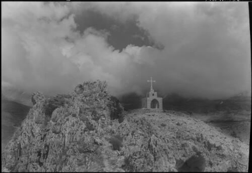 Lebanons on way to Cedars [crucifix mounted on a stone structure or shrine in foreground] [picture] : [Lebanon, World War II] / [Frank Hurley]