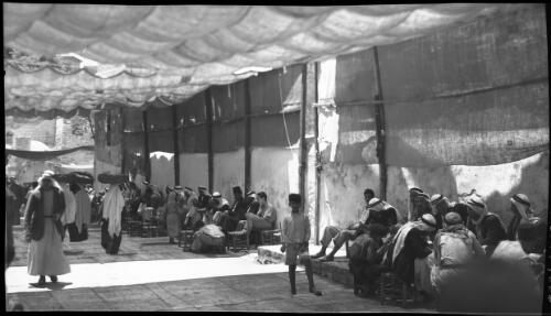 Cafe scene where the Arabs gather to gossip, smoke-sip coffee near the Damascus Gate [Jerusalem] [picture] / [Frank Hurley]