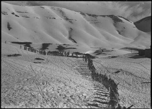At Cedars Lebanon [members of 1st Australian Ski Corps marching in file with skis across mountain face, ca. 1941] [picture] : [Lebanon, World War II] / [Frank Hurley]