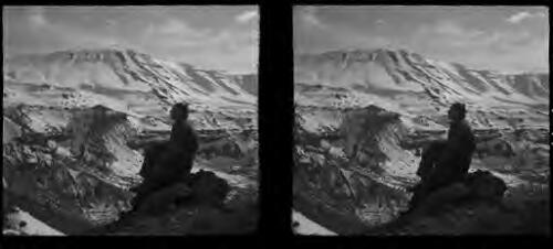 Cedars of Lebanon [Frank Hurley posing in profile-seated on a rock, mountain range behind] [picture] : [Lebanon, World War II] / [Frank Hurley]