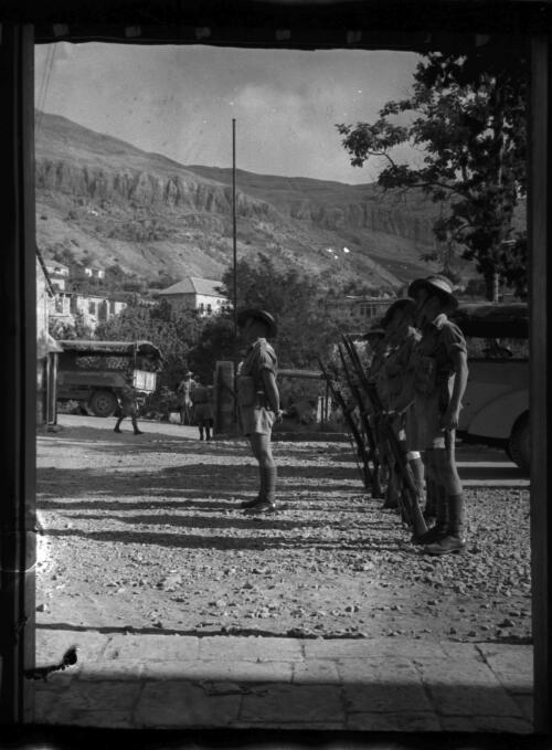 Damas near Becharee [Bcharre, taken through an entrance with Australian troops standing to attention, village and mountains behind] [picture] : [Lebanon, World War II] / [Frank Hurley]