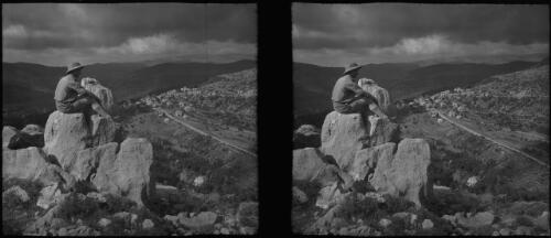 Near Ain Sofa Lebanons [lone figure atop rock overlooking valley and village below] [picture] : [Lebanon, World War II] / [Frank Hurley]