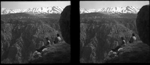 Wady Qadisha Lebanons [two young boys in foreground looking across gorge to village and mountains in distance] [picture] : [Lebanon, World War II] / [Frank Hurley]