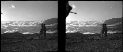 [Panoramic mountain view of cloud filled valley surveyed by two figures] [picture] : [Lebanon, World War II] / [Frank Hurley]