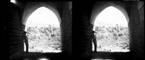 The New Hotel Aby [view through stone archway to hillside village] [picture] : [Lebanon, World War II] / [Frank Hurley]