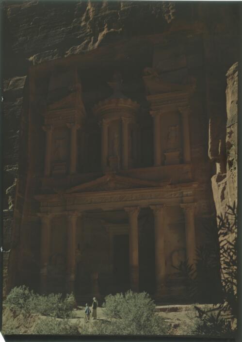 [Two figures at entrance gaze up at the monument, the Treasury, Petra] [picture] : [Jordan, World War II] / [Frank Hurley]