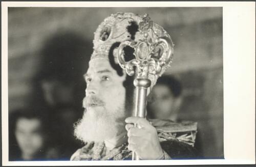 [Close-up of priest in richly decorated ceremonial crown and staff during Greek Service in Church of the Holy Sepulchre, Jerusalem] [picture] / [Frank Hurley]