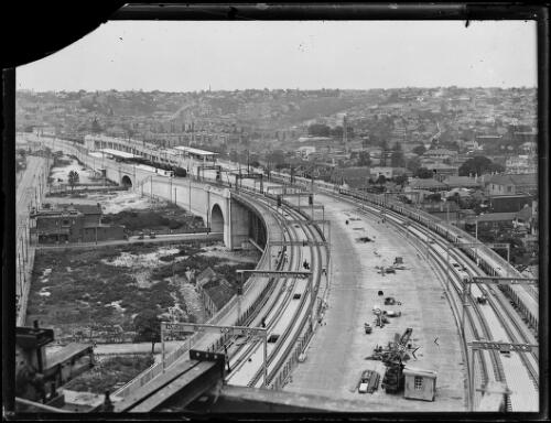 Construction work on the pylons of Sydney Harbour Bridge and locomotives at Milson's Point station, New South Wales, ca. 1931 [picture]