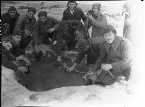 Italian prisoners of war filling water bottles near Tocra, Libya, ca. 1943 [picture] / [Frank Hurley]