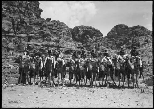 [Ten soldiers with Arab headdress mounted on camels] [picture] : [Petra Valley, Jordan] / [Frank Hurley]
