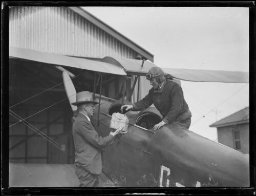 Pilot in a sun moth plane being handed a package by another man, New South Wales, 23 October 1929 [picture]