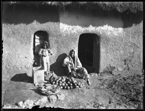 [Man and child with food produce, Middle East] [picture] / [Frank Hurley]