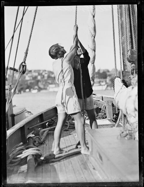 Captain Mr G.H. Metcalf and his wife hoisting the sail onboard the yacht Gullmarn, New South Wales, 21 April 1932 [picture]