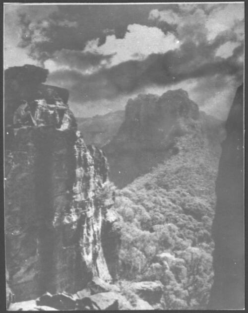 [The Bluff, an abrupt terminal of the Narrow Neck Spur, with the Ruined Castle Rocks in the foreground, horizontal shot] [picture] : [Blue Mountains, New South Wales] / [Frank Hurley]
