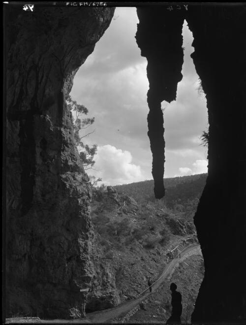 Looking out of entrance with silhouette stalagmite [Yarrangobilly Caves, New South Wales] [picture] / [Frank Hurley]