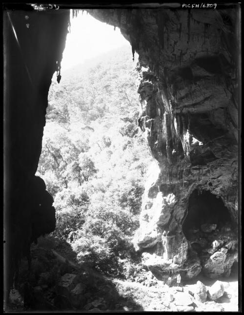 Devil's Coachhouse (with figures) [picture] : [Jenolan Caves, New South Wales] / [Frank Hurley]