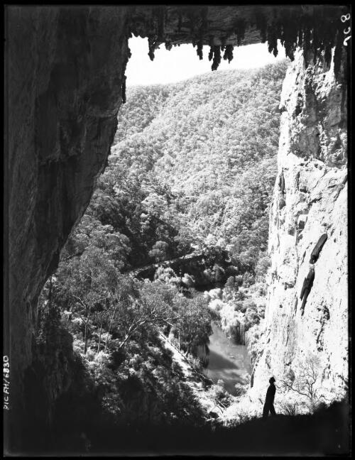 Carlotta Arch with figure at bottom [picture] : [Jenolan Caves, New South Wales] / [Frank Hurley]