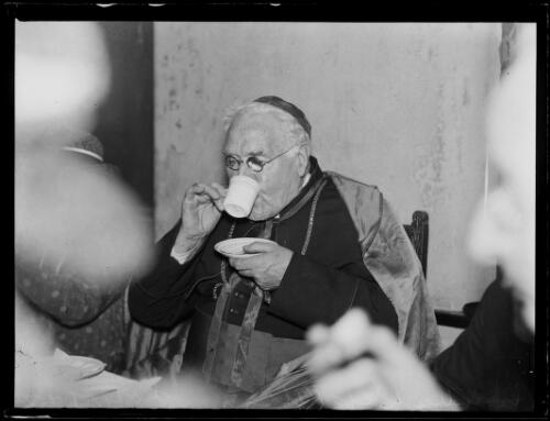 Archbishop Kelly drinking a cup of tea wearing Episcopal robes, New South Wales, ca. 1930s [picture]