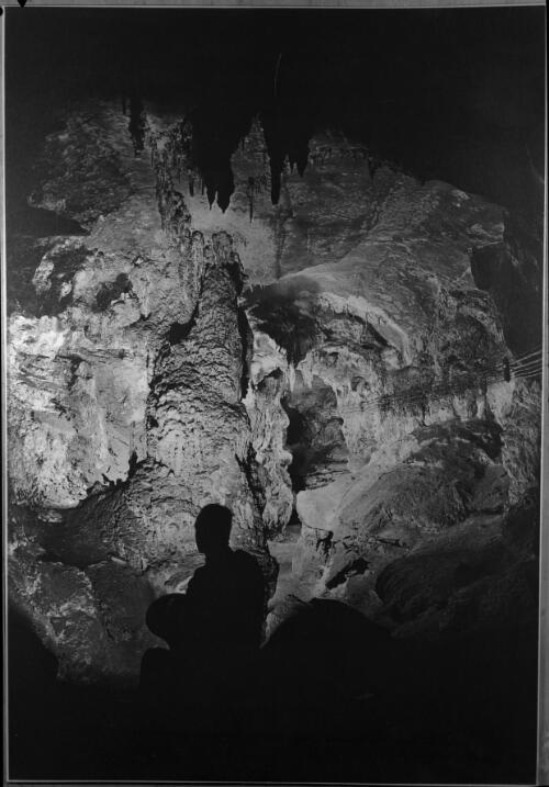 [A figure silhouetted against an entrance to a cave] [picture] : [Jenolan Caves, New South Wales] / [Frank Hurley]