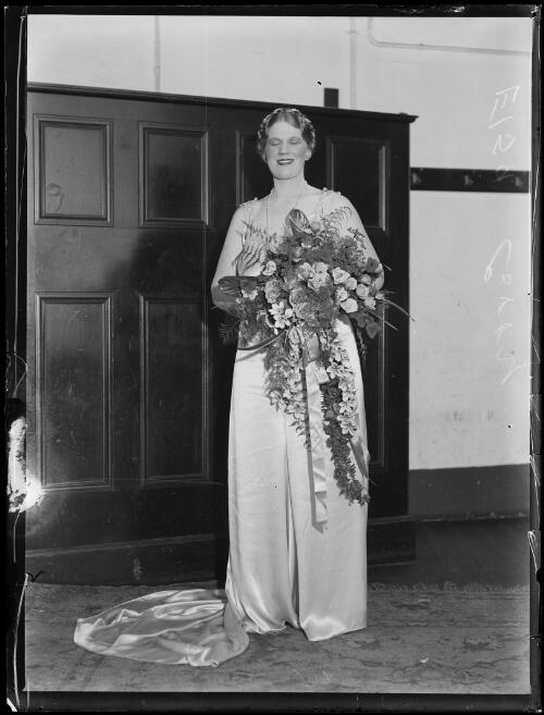 Miss Elsa Corry holding a bunch of flowers after her concert, Town Hall, Sydney, 13 April 1934, 1 [picture]
