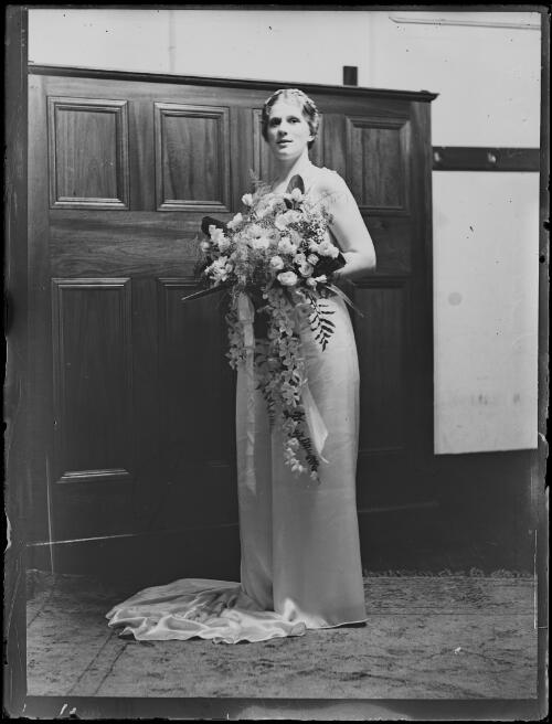 Miss Elsa Corry holding a bunch of flowers after her concert, Town Hall, Sydney, 13 April 1934, 2 [picture]